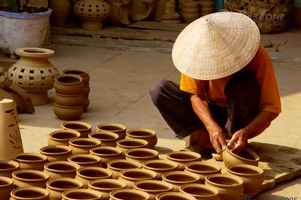 A local artisan crafting traditional pottery by hand in Thanh Ha Pottery Village, Hoi An