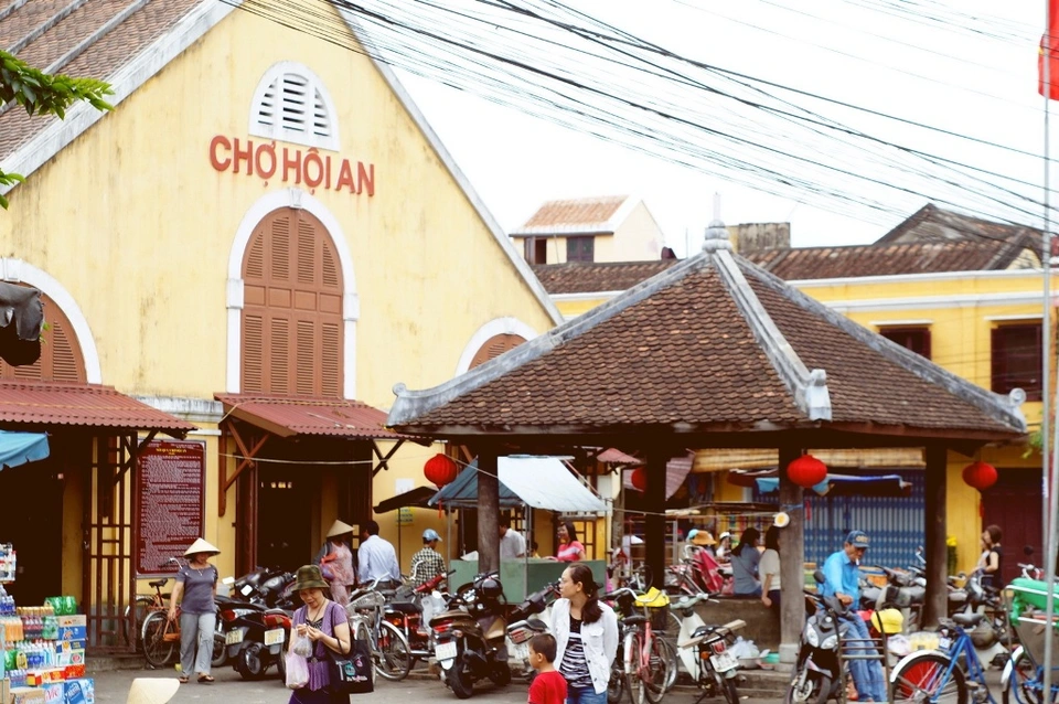 Bustling Hoi An Market with locals and tourists shopping for fresh produce and souvenirs